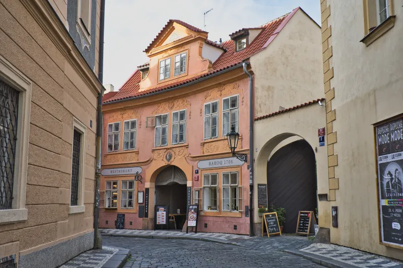 Historisches Altstadt-Restaurant mit barocker Fassade und Kopfsteinpflastergasse in Prag
