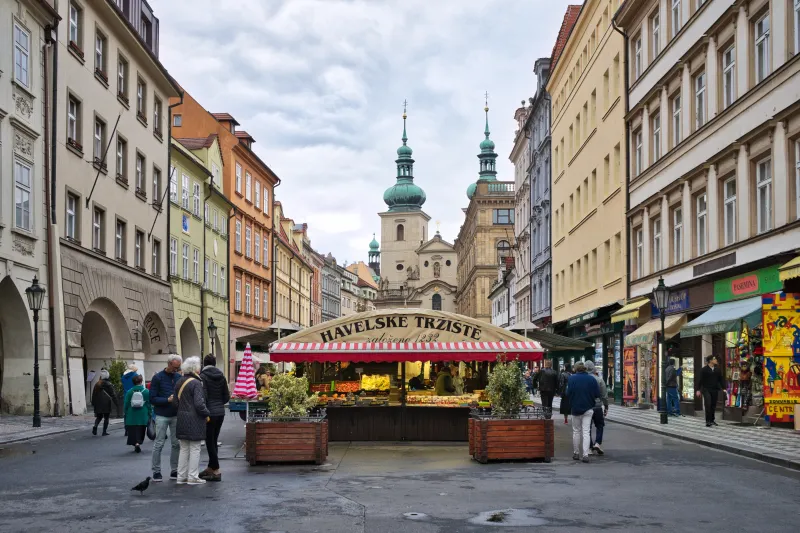 Prag mit historischem Marktpavillon, umliegenden Altstadtgebäuden und Fußgängerzone bei Tageslicht
